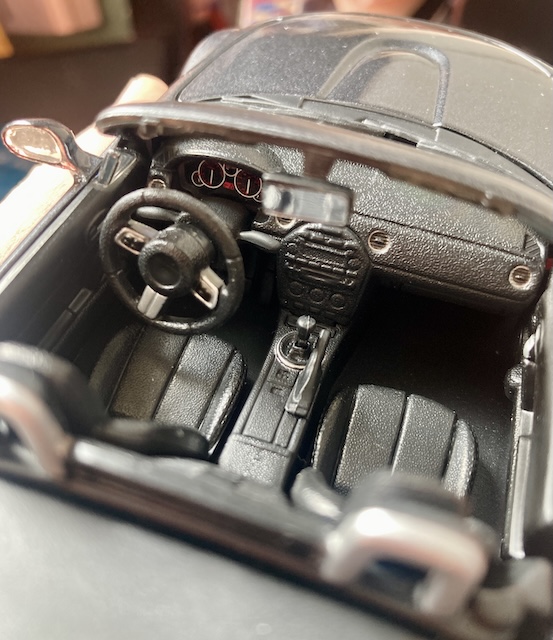 The dashboard, featuring a shifter and handbrake. The Mazda logo has fallen off the steering wheel.