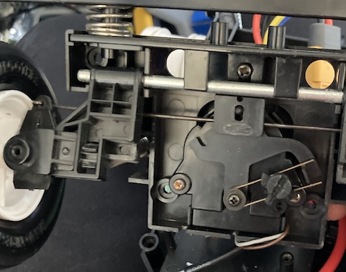 The Beetle's steering rack: a piece of steel that pushes the wheels in and out, connected to an offset steering arm that is connected to a biasing adjustment on a second rack. Only two wires run to it.