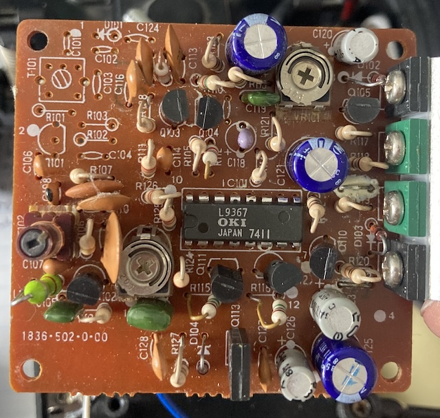 The board has been removed from the car, showing a tangle of parts.
