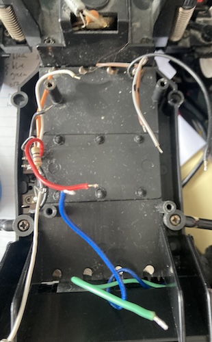 The empty chassis of the car after the electronics are removed. Only the charge-port circuitry and a bunch of loose wires remain.