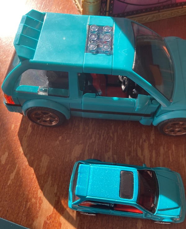 In the sun, you can see that the metal flake in the diecast is not present in the plastic model.