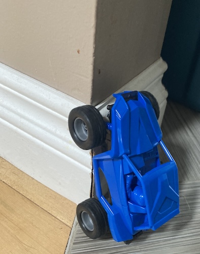 The Fun-Vroom has climbed the floor moulding of my wall and is trying to drive up the wall.