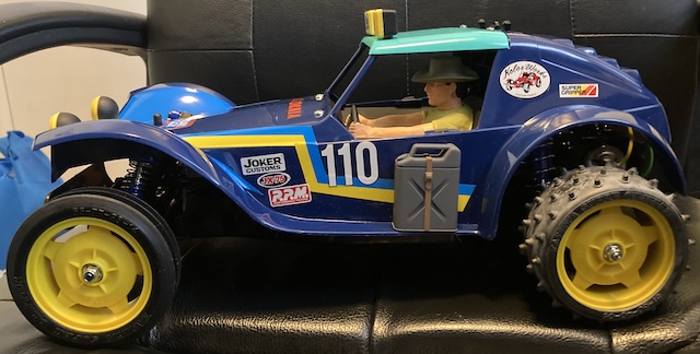 The driver is painted, assembled, and sitting in the cab of the car.