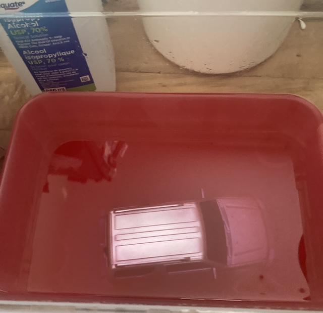 The car body sits in a pile of red soup. It still looks silver.
