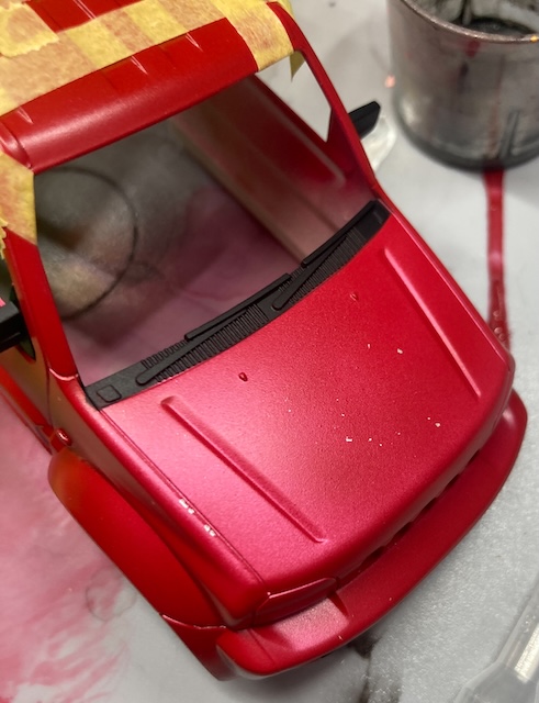A bunch of red paint is missing from the hood.