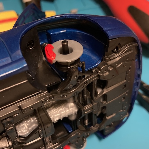 The front right brake caliper is nice and red. The rotor around it is both unpainted, and still has an unsightly sprue-cut line on the bottom.