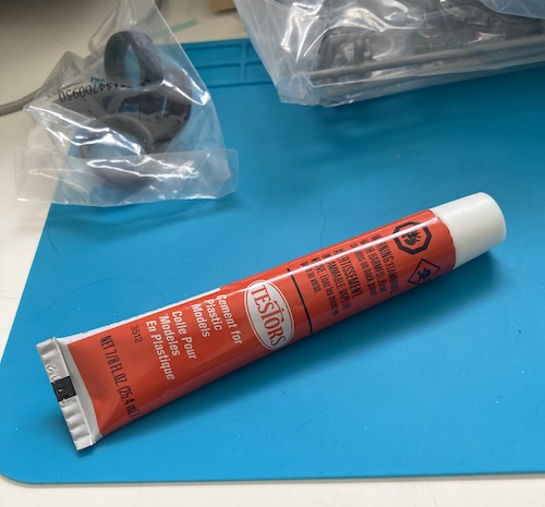 A huge orange-red tube of Testors model cement.