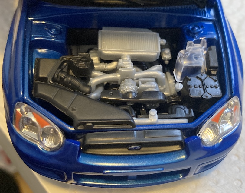 The assembled engine bay. Check out the timing cover, intercooler, 12-volt battery, and clear washer fluid jug.