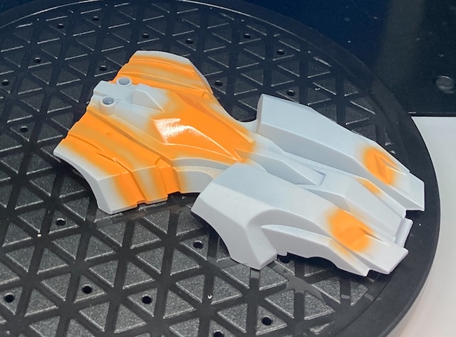 Orange highlights are sprayed into the innermost detail areas of the car, including the motor hump.