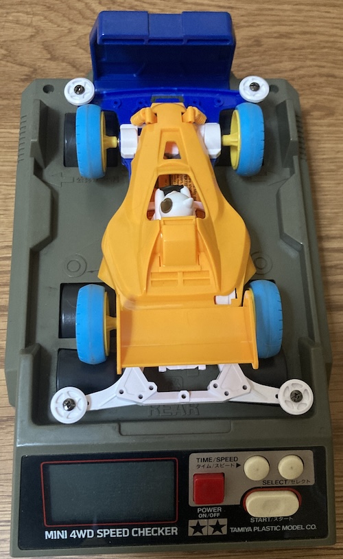 An orange Cat Racer with no stickers is lying on the dyno.