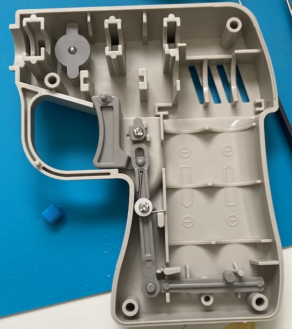 The dark-grey switch linkage worms its way from the trigger of the router, all the way down the handle to where the battery terminals will live at the end.